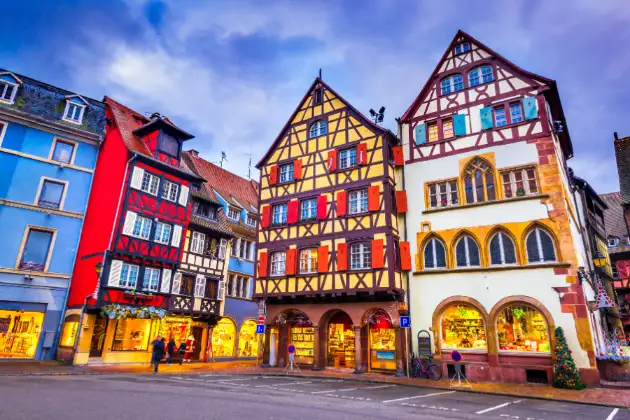 Casas vibrantes com estrutura de madeira aparente em Colmar, exibindo a arquitetura tradicional da região da Alsácia na França.