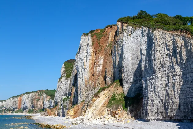 Paisagem costeira dramática com as icônicas falésias de calcário branco esculpidas pela natureza em Étretat, Normandia.