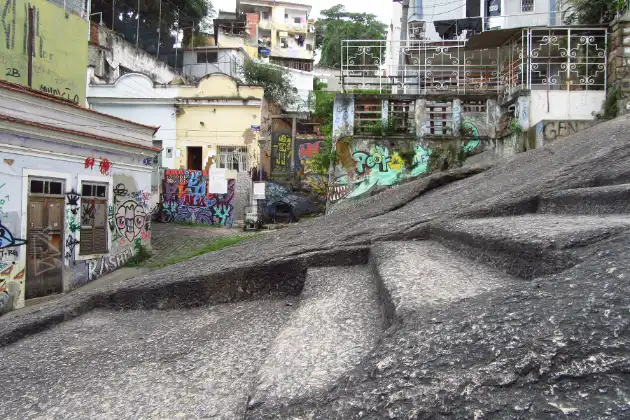 Rua em Santa Teresa, Rio de Janeiro, com grafites coloridos e escadaria de pedra. Pontos turísticos Rio de Janeiro.