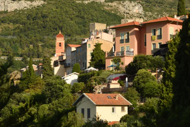 Vista pitoresca de uma vila francesa com edifícios coloridos e torre da igreja. Pontos turísticos na França.