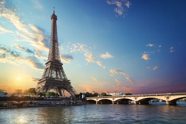 Paisagem urbana icônica de Paris com a majestosa Torre Eiffel e a elegante Pont d'Iéna sobre o Sena, capturada em uma bela luz.