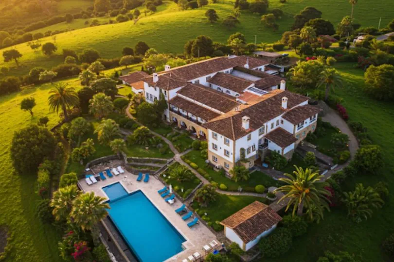 Pousada sofisticada com piscina azul e jardins bem cuidados, cercada por colinas verdes em Gramado, Serra Gaúcha.