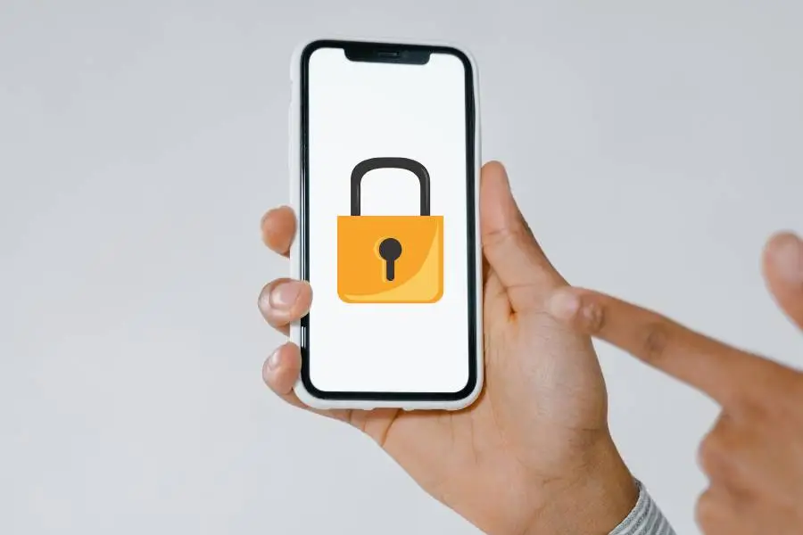 Mão segurando smartphone com ícone de cadeado na tela, representando proteção de dados.