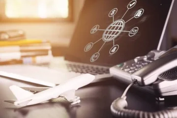 Miniatura de avião, computador com globo online e telefone, representando conexão em viagens