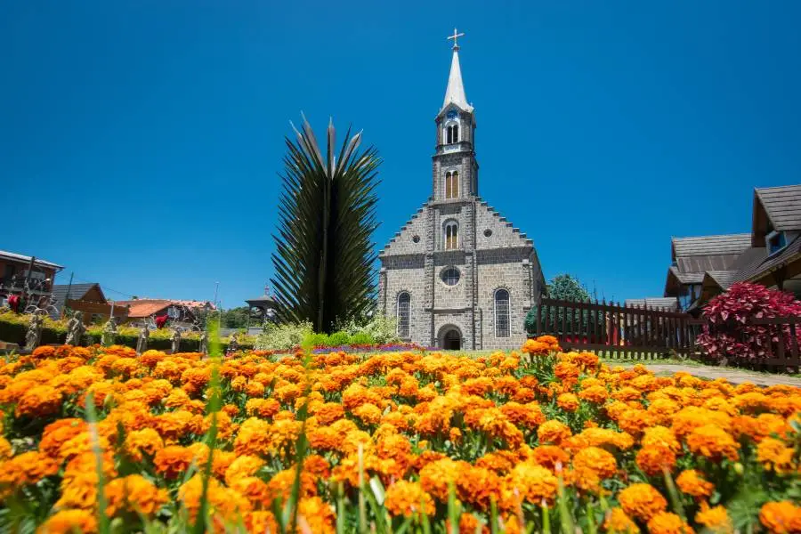 Igreja de pedra em estilo gótico com jardim florido em Gramado, Rio Grande do Sul.