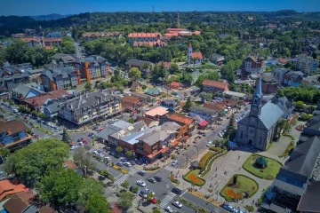 Vista aérea da cidade de Gramado com sua arquitetura europeia e a Igreja Matriz em destaque.