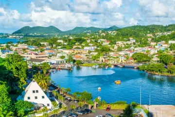 Vista panorâmica da cidade costeira de Santa Lúcia com baía azul e vegetação tropical.