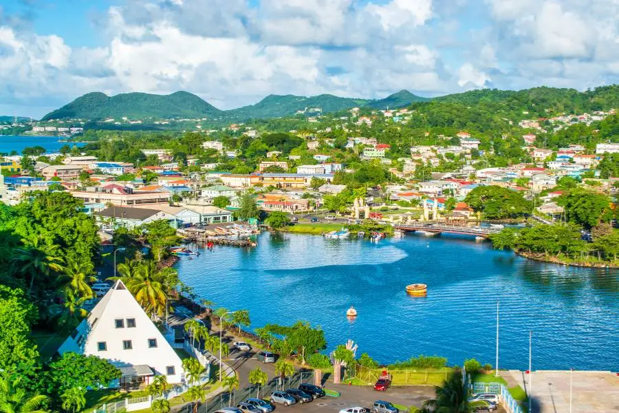 Vista panorâmica da cidade costeira de Santa Lúcia com baía azul e vegetação tropical.