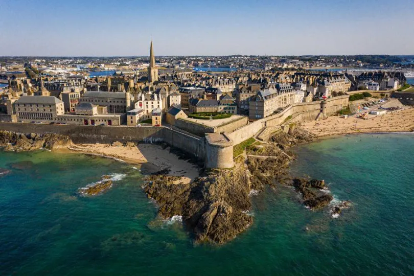 Cidade costeira de Saint-Malo na Bretanha, França, com muralhas medievais protegendo a cidade antiga à beira-mar.